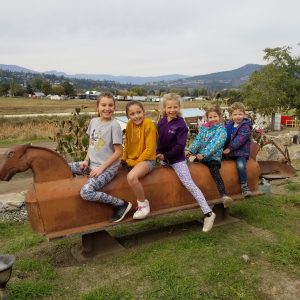 A group of people sitting on top of a wooden horse.