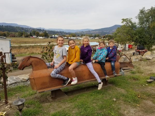 A group of people sitting on top of a wooden horse.